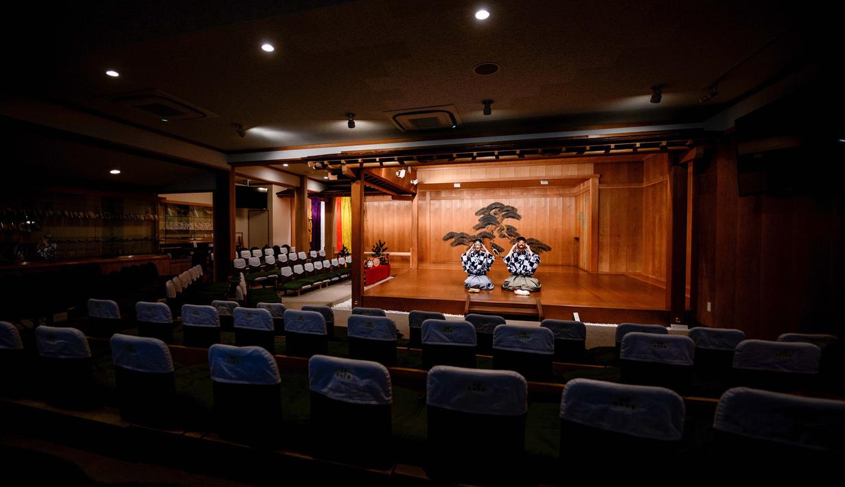Kanta Nakamori (kiri) dan putranya Kennosuke Nakamori mengenakan topeng saat berlatih di Kamakura Noh Theatre, Kamakura, Prefektur Kanagawa, Jepang, 29 Juli 2020. Pandemi COVID-19 telah memengaruhi teater di seluruh dunia, termasuk drama sejak abad ke-14 ini. (Philip FONG/AFP)