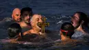 Umat Ortodoks Yunani mencium kayu salib setelah diambil di Tanduk Emas saat perayaan Epiphany di Istanbul, Turki, 6 Januari 2022. Epiphany adalah sebuah hari raya keagamaan dalam sejumlah denominasi gereja Kristen pada tanggal 6 Januari. (AP Photo/Francisco Seco)