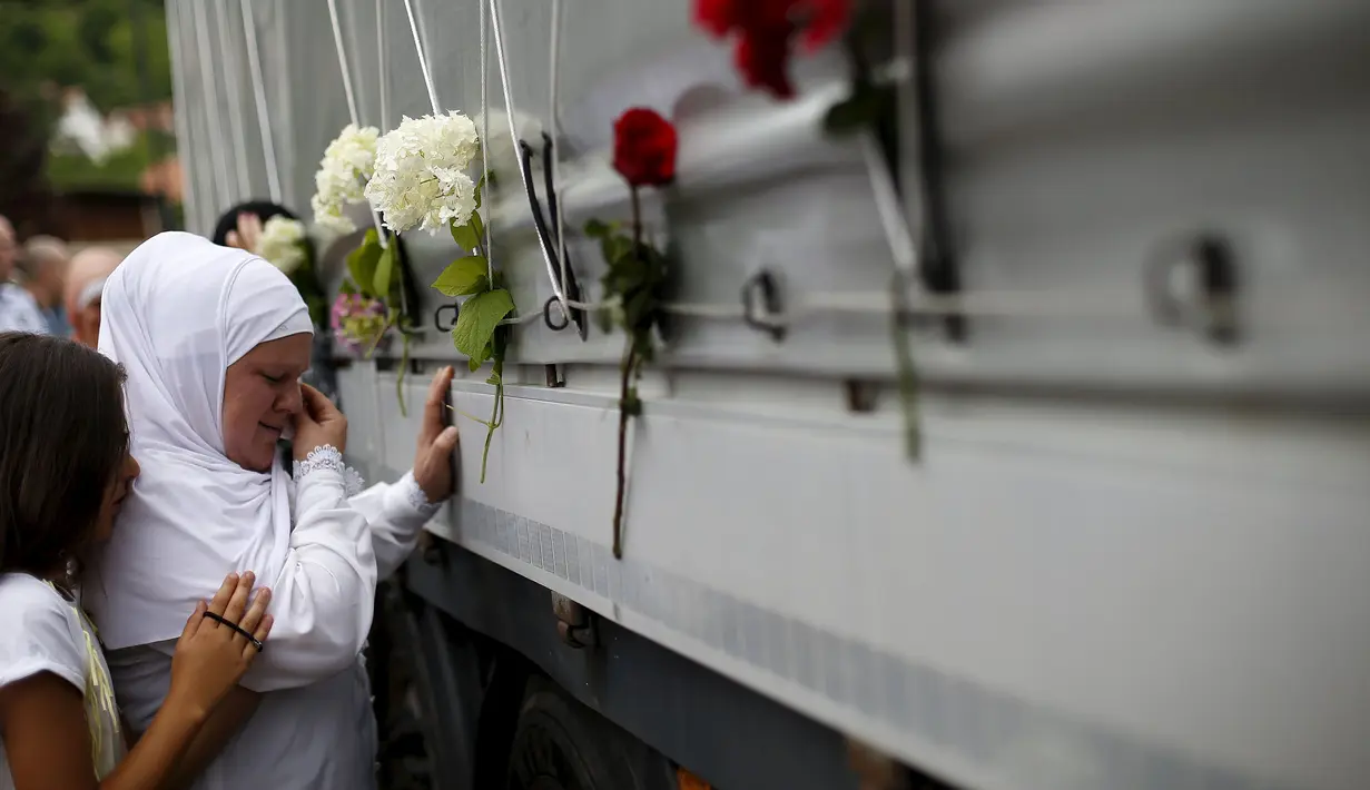 Wanita menangis di depan sebuah truk yang membawa 136 korban yang baru diidentifikasi di desa Visoko, Bosnia-Herzegovina, Kamis, (9/7/2015). Para Jenazah akan diangkut ke pusat peringatan di Potocari.(REUTERS/Stoyan Nenov)
