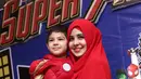 Dengan mengenakan hijab warna merah dan busana warna gelap, Risty sibuk mendampingi anaknya. (Andy Masela/Bintang.com)