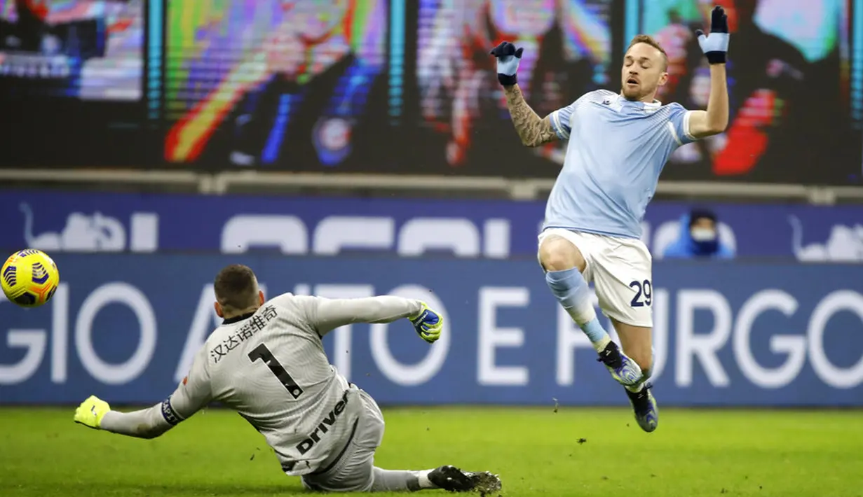 Pemain Lazio Manuel Lazzari mencoba mencetak gol ke gawang Inter Milan pada pertandingan Liga Italia di Stadion San Siro, Milan, Italia, Minggu (14/2/2021). Inter Milan akhirnya menggusur AC Milan dari puncak klasemen Liga Italia usai mengalahkan Lazio 3-1. (AP Photo/Luca Bruno)