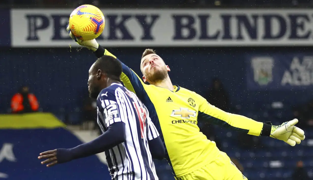 Pemain West Bromwich Albion, Mbaye Diagne, berebut bola dengan kiper Manchester United, David de Gea, pada laga Liga Inggris di Stadion Hawthorns, Minggu (14/2/2021). Kedua tim bermain imbang 1-1. (Nick Potts/Pool Photo via AP)