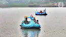 Warga berkeliling dengan menggunakan perahu wisata di Setu Babakan, Jagakarsa, Jakarta Selatan, Minggu (4/4/2021). Kios yang boleh dibuka bergantian dengan sistem tanggalan ganjil genap. (merdeka.com/Arie Basuki)