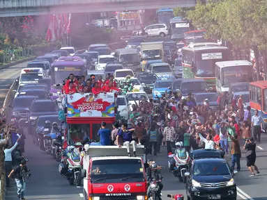 Warga antusias melihat arak-arakan para penyumbang medali Indonesia di Olimpiade Rio 2016 saat melintas menuju Istana Negara, Jakarta, Rabu (24/8). Rombongan para peraih medali ini memulai arak-arakan dari Gedung Kemenpora. (Liputan6.com/Angga Yuniar)