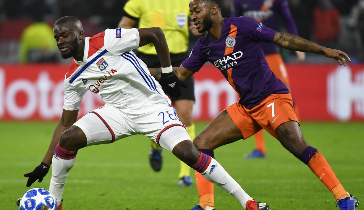 Pemain Lyon, Tanguy Ndombele berduel dengan Raheem Sterling pada laga lanjutan liga champions yang berlangsung di stadion Parc Olympique Lyonnais, Prancis, Rabu (28/11). Lyon bermain imbang 1-1 kontra Manchester City. (AFP/Jeff Pachoud)