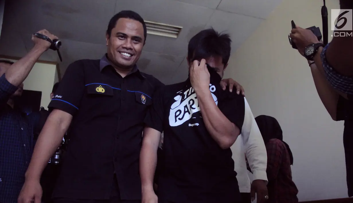 Salah satu tersangka dikawal petugas sebelum konferensi pers terkait narkoba di  Polda Gorontalo, Senin (13/5/2019). Ditresnarkoba Polda Gorontalo mengamankan 2 orang, yakni lelaki berinisial WR dan seorang lagi perempuan yang belakangan menempuh rehabilitasi oleh BNNP. (Liputan6.com/Arfandi ibrahim