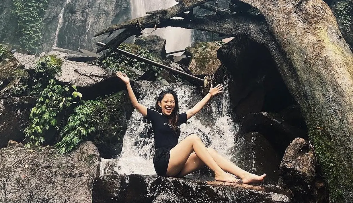 Natalie Zenn terlihat ceria saat berada di bawah air terjun dengan aliran air yang terbilang deras. Tak takut hanyut, wanita 22 tahun ini sukses mencuri perhatian lewat penampilannya dengan outfit santai. (Liputan6.com/IG/@nataliezenn24)