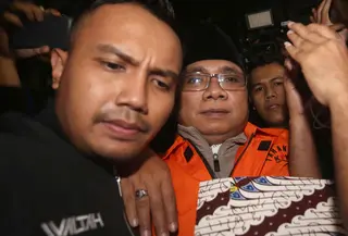 KPK secara resmi mengumumkan penetapan dua tersangka dalam perkara ini pada Jumat 9 Januari 2026, yakni Yaqut Cholil Qoumas dan Ishfah Abidal Aziz alias Gus Alex. Yaqut Cholil Qoumas melakukan perlawanan hukum dengan mengajukan permohonan praperadilan. Tampak dalam foto, mantan Menteri Agama, Yaqut Cholil Qoumas, saat dibawa menuju mobil tahanan di Gedung Merah Putih Komisi Pemberantasan Korupsi (KPK), Jakarta, Kamis (12/3/2026). (Liputan6.com/Helmi Fithriansyah)