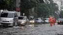 Petugas PPSU mengatur lajur kendaraan saat banjir menggenangi Jalan DI Panjaitan, Jakarta, Senin (3/12). Menurut petugas, banjir disebabkan oleh buruknya sistem drainase atau gorong-gorong. (Merdeka.com/ Iqbal S. Nugroho)