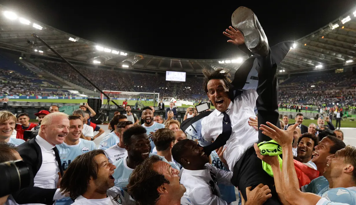 Pelatih Lazio, Simone Inzaghi melakukan selebrasi bersama pemainnya usai meraih trofi pada pertandingan final Piala Super Italia di stadion Olimpiade Roma, Italia (13/8). Lazio menang atas Juventus dengan skor 3-2. (AP Photo / Gregorio Borgia)