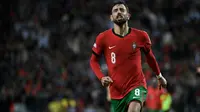 Gelandang Portugal, Bruno Fernandes, merayakan gol ketiga mereka selama pertandingan UEFA Nations League, Liga A, Grup 1 antara Portugal dan Polandia di stadion Dragao di Porto, Sabtu dini hari WIB (16/11/2024). (Miguel RIOPA/AFP)