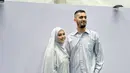 Vebby Palwinta tampil serasi dengan sang suami kenakan busana muslim silver keabuan. Vebby sendiri terlihat cantik dengan hijab panjang.Vebby kenakanleated dress dan outer chiffon. Sang suami kenakan kemeja satin panjang bermotif serupa [@vebbypalwinta]
