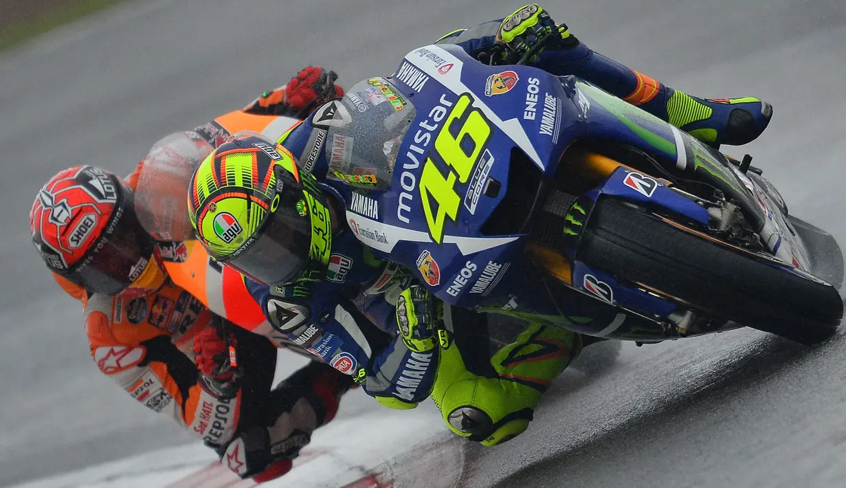 Ketegangan berlanjut saat Rossi mampu meraih juara pada MotoGP Belanda 2015 yang berlangsung di Sirkuit Assen. Rossi dinilai melakukan hal kontroversial usai menyalip Marquez lewat 'jalan pintas' atau gravel di lap terakhir untuk merebut posisi terdepan. (AFP/Glyn Kirk)