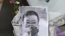 Karangan bunga dan foto mendiang dokter Li Wenliang terlihat di Cabang Houhu Rumah Sakit Pusat Wuhan di Wuhan di provinsi Hubei, China, Jumat, (7/2/2020). Li Wenliang sebelumnya memberikan peringatan kepada publik tentang potensi munculnya virus corona pada Desember 2019. (AFP/STR)