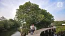 Wisatawan berjalan di jembatan saat mengunjungi Taman Wisata Hutan Bakau (Mangrove) di Desa Segarajaya, Tarumajaya, Bekasi, Jawa Barat (24/11/2019). Taman wisata hutan bakau ini menjadi salah satu destinasi favorit untuk mengisi liburan akhir pekan. (merdeka.com/Iqbal S. Nugroho)