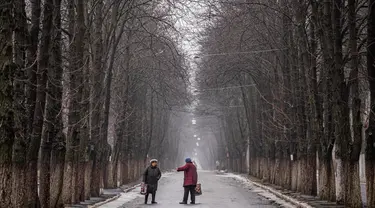 Foto 1: Warga setempat berbincang di sebuah jalan di Chasiv Yar, dekat Bakhmut pada 28 Februari 2023. Pihak berwenang Ukraina mengatakan pada 28 Februari, pasukannya berada di bawah tekanan di Bakhmut, sebuah kota yang hampir hancur di wilayah Donetsk timur yang telah berusaha direbut Rusia selama berbulan-bulan. (Dimitar DILKOFF/AFP)