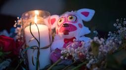 Lilin, bunga, dan boneka binatang menjadi simbol duka dalam aksi mengenang korban penembakan di sekolah Santa Fe, Texas, Amerika serikat, Jumat (18/5). Sebagian besar korban tewas dalam penembakan Texas merupakan para siswa. (AFP)