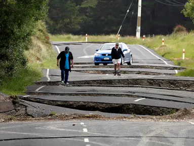 Warga melihat jalan retak di jalan raya State Highway One, sebelah selatan dari Blenheim di Pulau Selatan, Selandia Baru, Senin (14/11). Gempa 7,8 SR yang mengguncang Selandia Baru mengakibatkan jalan tersebut retak. (REUTERS/Anthony Phelps)