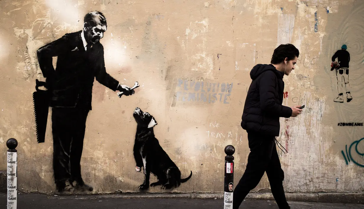 Seorang pria berjalan melewati mural yang diduga karya seniman sekaligus aktivis Banksy di Paris, Prancis, Minggu (24/6). Tujuh mural terbaru telah ditemukan di Paris dalam beberapa hari terakhir. (PHILIPPE LOPEZ/AFP)