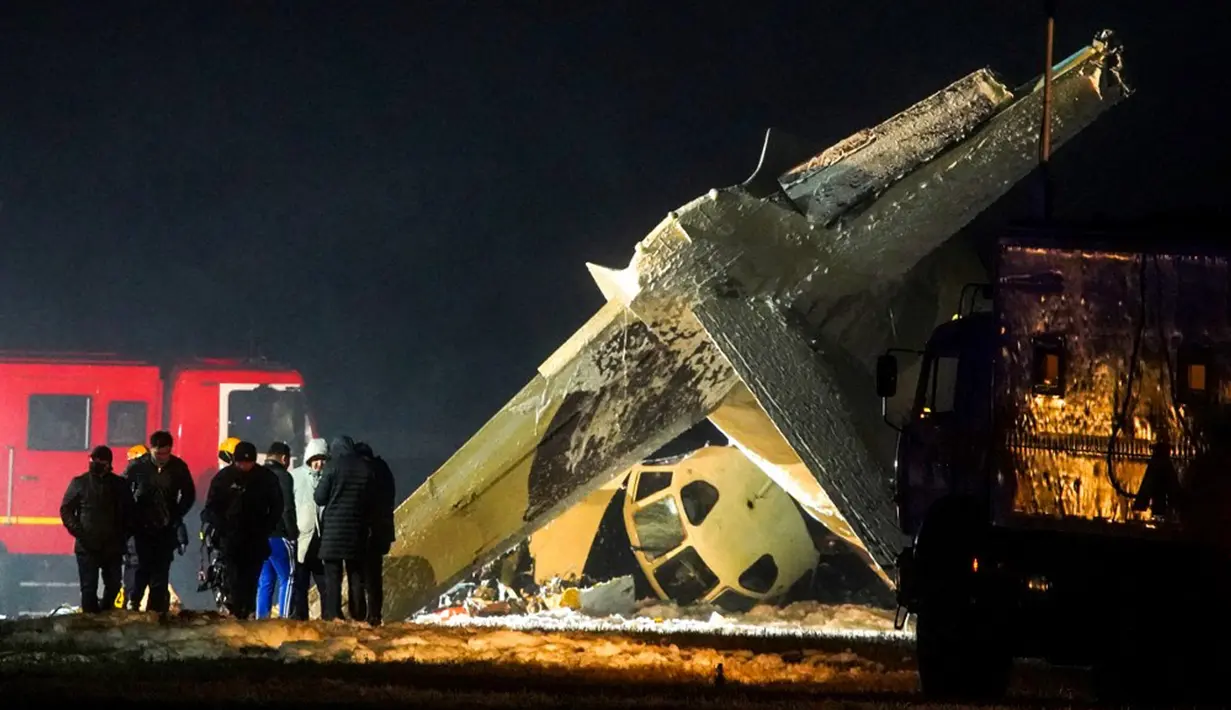 Penyelidik bekerja di lokasi jatuhnya pesawat Antonov An-26 di Bandara Almaty, Kazakhstan, Sabtu (13/3/2021). Pesawat yang terbang dari ibu kota Kazakhstan, Nursultan, tersebut jatuh saat mendarat di Bandara Almaty. (Abduaziz MADYAROV/AFP)