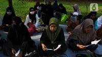Umat Islam membaca Al-Quran sambil menunggu waktu berbuka puasa di halaman Masjid Raya Jakarta Islamic Center, Jakarta Utara, Senin (18/4/2022). Acara ngabuburit sambil khataman Al-Quran ini merupakan rangkaian acara menyambut 17 Ramadhan atau malam Nuzulul Quran. (Liputan6.com/Herman Zakharia)