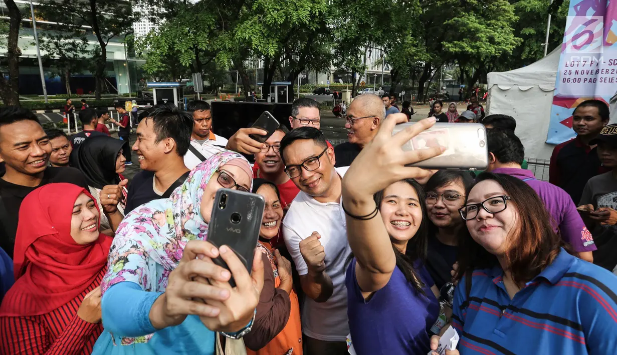 Gubernur Jawa Barat Ridwan Kamil berswafoto bersama warga saat Family Day Artha Graha Peduli (AGP) di Pasar Akhir Pekan SCBD, Jakarta, Minggu (25/11). Kehadiran pria yang akrab disapa Emil itu menjadi rebutan warga berswafoto. (Liputan6.com/Fery Pradolo)