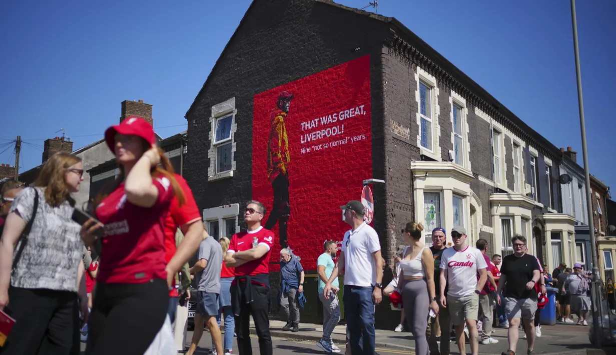 Penggemar berjalan melewati mural pelatih Liverpool Jurgen Klopp menjelang laga pekan ke-38 Premier League melawan Wolverhampton Wanderers di Stadion Anfield, Minggu (19/5/2024). (AP Photo/Jon Super)