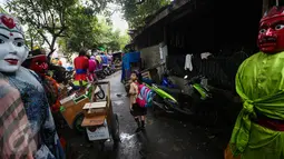 Seorang anak kecil mengamati ondel-ondel yang selesai dibuat di kawasan Kramat, Jakarta, Kamis (26/1). Di awal kemunculannya, ondel-ondel ini berfungsi sebagai penolak bala dari gangguan roh halus yang mengganggu. (Liputan6.com/Faizal Fanani)