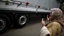 Seorang wanita berdoa di depan truk yang membawa 136 peti mati korban pembantaian Srebrenica, di desa Visoko, Bosnia-Herzegovina, Kamis, (9/7/2015). ini merupakan pembantaian terburuk di Eropa sejak Perang Dunia II. (REUTERS/Stoyan Nenov)