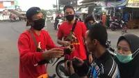 Pemain Persikabo, Gustur Cahyo, membagikan masker di Magelang, belum lama ini. (Bola.com/Permana Kusumadijaya)