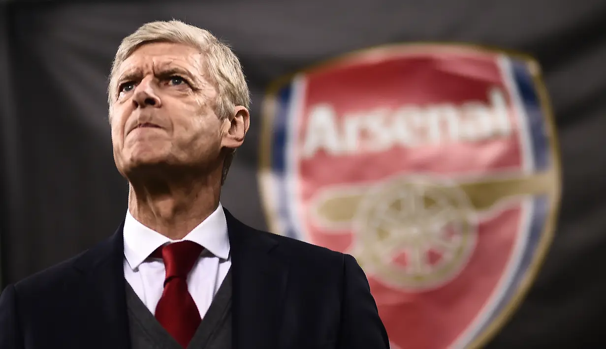 Raut wajah pelatih Arsenal, Arsene Wenger saat pertandingan antara AC Milan melawan Arsenal pada leg pertama 16 besar Liga Europa, di San Siro, Milan, Italia, Kamis (8/3). AC Milan takluk 0-2 dari Arsenal. (MARCO BERTORELLO/AFP)