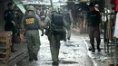 Petugas mengenakan kostum anti-bom mengecek sebuah pasar setelah terjadi bom motor di Provinsi Yala, Thailand (22/1). Sampai saat ini belum ada kelompok maupun pihak tertentu yang bertanggung jawab atas ledakan ini. (AFP Photo/Tuwaedaniya Meringing)