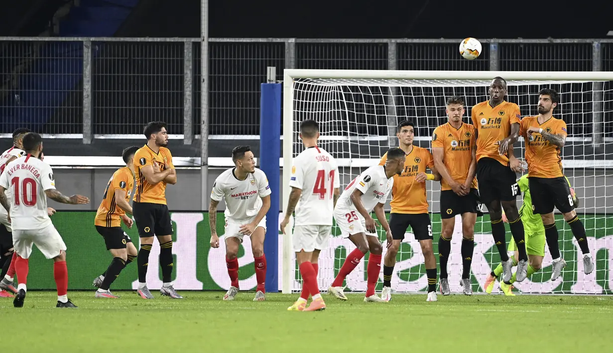 Pemain Sevilla Ever Banega (kiri) melakukan tendangan bebas ke gawang Wolverhampton Wanderers pada perempat final Liga Europa di MSV Arena, Duisburg, Jerman, Selasa (11/8/2020). Sevilla lolos ke semifinal usai mengalahkan Wolverhampton Wanderers 1-0. (Ina Fassbender/Pool Photo via AP)