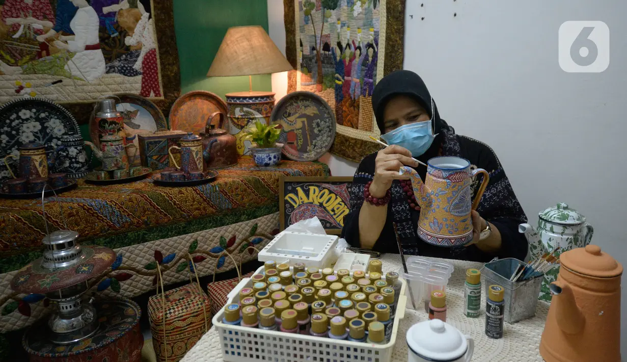 Perajin batik lukis ketel Nova Muhidir menyelesaikan lukisan batik di Studio Daroolang, Bintara, Tangerang Selatan, Banten, Rabu (2/12/2020). Lukisan ketel batik jadul khas nusantara di teko tempat air minum tersebut dijual dengan harga Rp 150 ribu hingga Rp 2,5 juta. (merdeka.com/Dwi Narwoko)