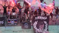 Aremania menyalakan flare usai ujicoba Arema melawan NZR di Stadion Gajayana, Sabtu (6/7/2024). Mereka melepas rindu setelah hampir dua tahun tidak mendukung arema secara langsung. (Bola.com/Iwan Setiawan)