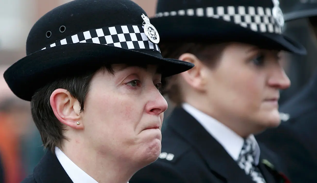 Seorang Polisi wanita menangis selama ikuti  upacara pemakaman di Gereja Anglican, Liverpool, Inggris, Senin (2/11/2015). Dave Phillips meninggal ditabrak saat mencoba memberhentikan sebuah mobil ketiga bertugas. (REUTERS/Darren Staples)