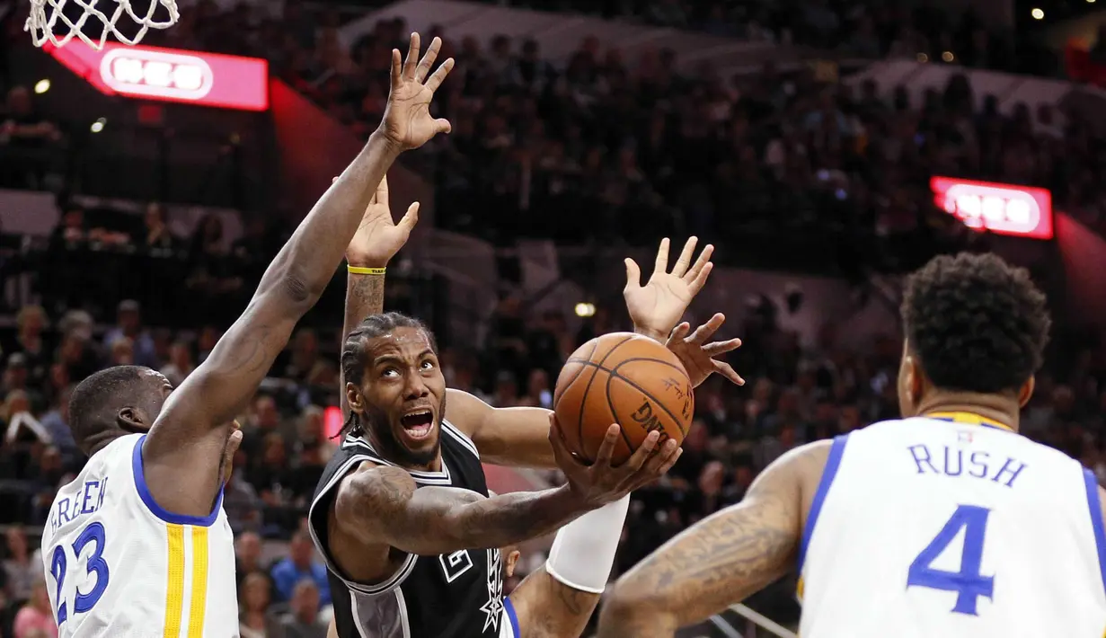 Pemain San Antonio Spurs, Kawhi Leonard (2), mencoba melewati hadangan para pemain Golden State Warriors pada lanjutan NBA di AT&T Center, San Antonio, AS, (10/4/2016). (Reuters/Soobum Im-USA Today Sports)