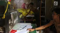Pekerja menyelesaikan pembuatan atribut partai di Jakarta, Senin (15/10). Dalam sehari, pekerja di pabrik konveksi tersebut bisa memproduksi hingga 2.000 potong atribut partai, mulai dari kaos, bendera, dan topi. (Liputan6.com/Immanuel Antonius)
