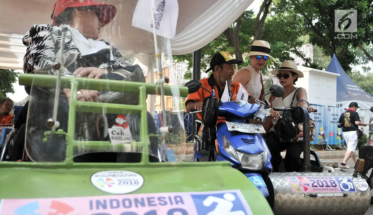 Pengunjung menggunakan jasa Ojek Disabilitas saat hendak menyaksikan pertandingan Asian Para Games 2018 di Gelora Bung Karno, Jakarta, Rabu (10/10). INAPGOC menyediakan sekitar 35 armada Ojek Disabilitas secara gratis. (Merdeka.com/Iqbal S. Nugroho)