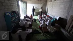 Murid SD mengikuti kegiatan belajar mengajar di Sekolah Terbuka, Kampung Manggar, Balikpapan, Kaltim, Kamis (29/10). Minimnya fasilitas, membuat kegiatan belajar terpaksa dilakukan di gudang bekas penyimpanan rumput laut. (Liputan6.com/Immanuel Antonius)