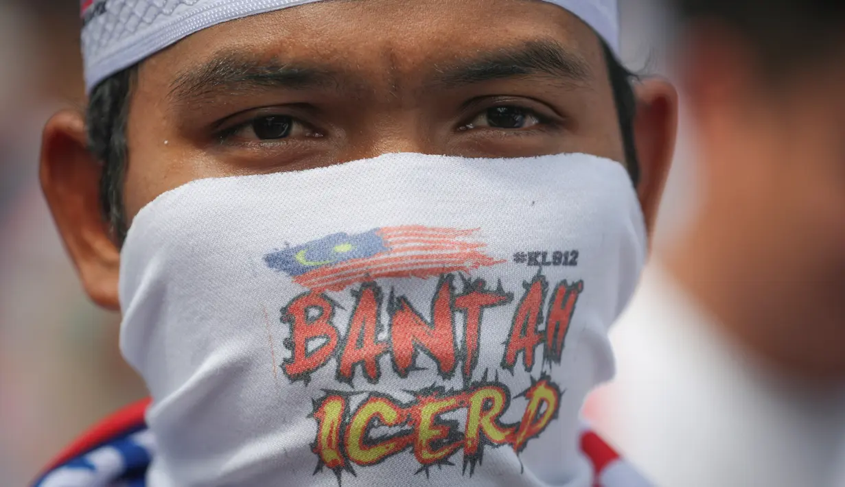 Pengunjuk rasa menutupi wajahnya mengambil bagian dalam rapat umum untuk memprotes langkah pemerintah yang tak meratifikasi konvensi anti-diskriminasi PBB, yang disebut ICERD di Kuala Lumpur, Malaysia (8/12). (AP Photo/Vincent Thian)