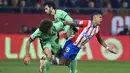 Gelandang Girona, Savio Moreira (kanan) ditekel gelandang Atletico Madrid, Axel Witsel saat perebutan bola pada laga pekan ke-19 Liga Spanyol 2023/2024 di Montilivi Stadium, Girona, Kamis (4/1/2024) dini hari WIB. (AFP/Pau Barrena)