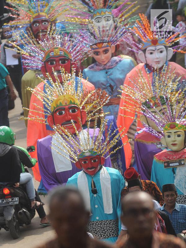 Ondel-ondel memeriahkan karnaval ulang tahun Kota Tangerang Selatan ke-10 di Ciputat, Tangerang Selatan, Minggu (11/11). Karnaval tersebut diikuti lebih dari seratus ondel - ondel se-kecamatan di Kota Tangerang Selatan. (Merdeka.com/Arie Basuki)