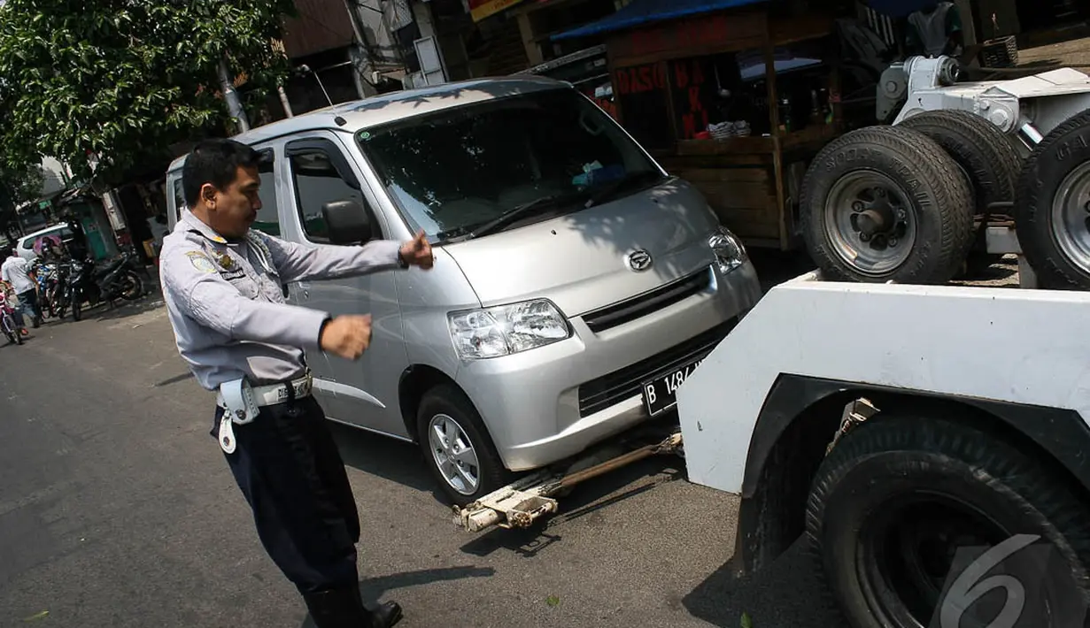 Seorang petugas Dishub memberikan instruksi bahwa derek pengait sudah terpasang dengan baik dan siap untuk diangkut, Jakarta, Kamis (18/9/2014) (Liputan6.com/Faizal Fanani)