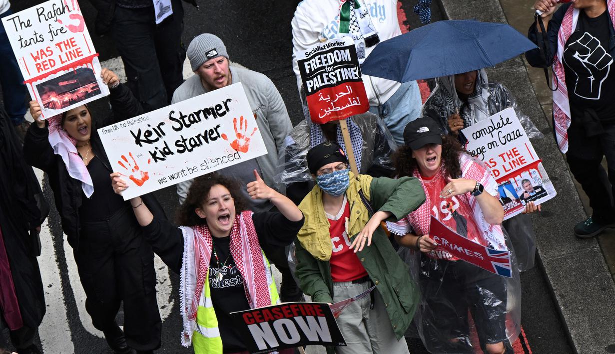 Dalam aksinya, para pengunjuk rasa pro-Palestina memegang plakat dan mengibarkan bendera. (JUSTIN TALLIS/AFP)