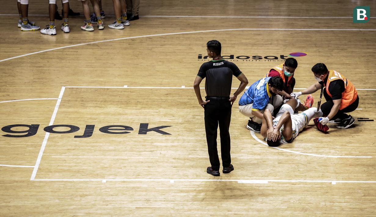 Ekspresi pemain Satya Wacana Salatiga, Henry Cornelis Lakay saat mendapatkan perawatan dari tim medis dalam laga lanjutan Seri 1 IBL 2022 melawan Bali United Basketball di Hall Basket GBK, Senayan, Kamis (20/01/2022). (Bola.com/Bagaskara Lazuardi)