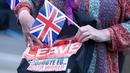 Pendukung Brexit memegang poster dan bendera Inggris di Westminster, London, Kamis (23/6). Perhitungan suara hasil Referendum Brexit menunjukkan mayoritas rakyat Inggris memilih “Brexit” alias keluar dari Uni Eropa. (REUTERS/Toby Melville)