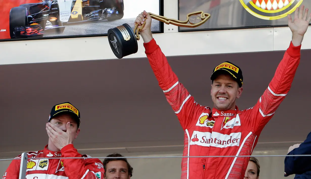 Pembalap Ferrari asal Jerman, Sebastian Vettel mengangkat trofi saat merayakan kemenangannya pada balapan GP Monaco di Sirkuit Monte Carlo, Minggu (28/5). Vettel finis pada urutan pertama dengan waktu satu jam 44 menit 44,340 detik (AP Photo/Claude Paris)