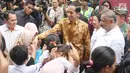 Presiden Jokowi bersalaman dengan warga saat menyaksikan pembagian paket Ramadan berupa sembako di Penjaringan, Jakarta, Selasa (13/6). Pembagian sembako ini merupakan inisiasi dari Kementerian BUMN dan perusahaan BUMN lainnya (Liputan6.com/Angga Yuniar)