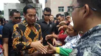 Presiden Joko Widodo membagikan sembako ke para tukang becak di Jalan Jendral Sudirman Palembang (Liputan6.com / Nefri Inge)